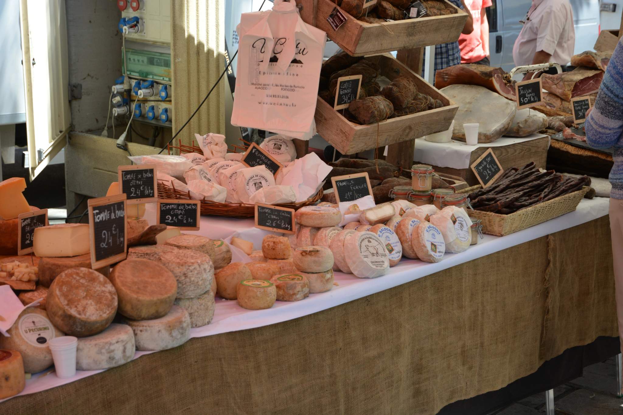 A stall featuring Corsican artisanal products at a traditional market in Corsica.