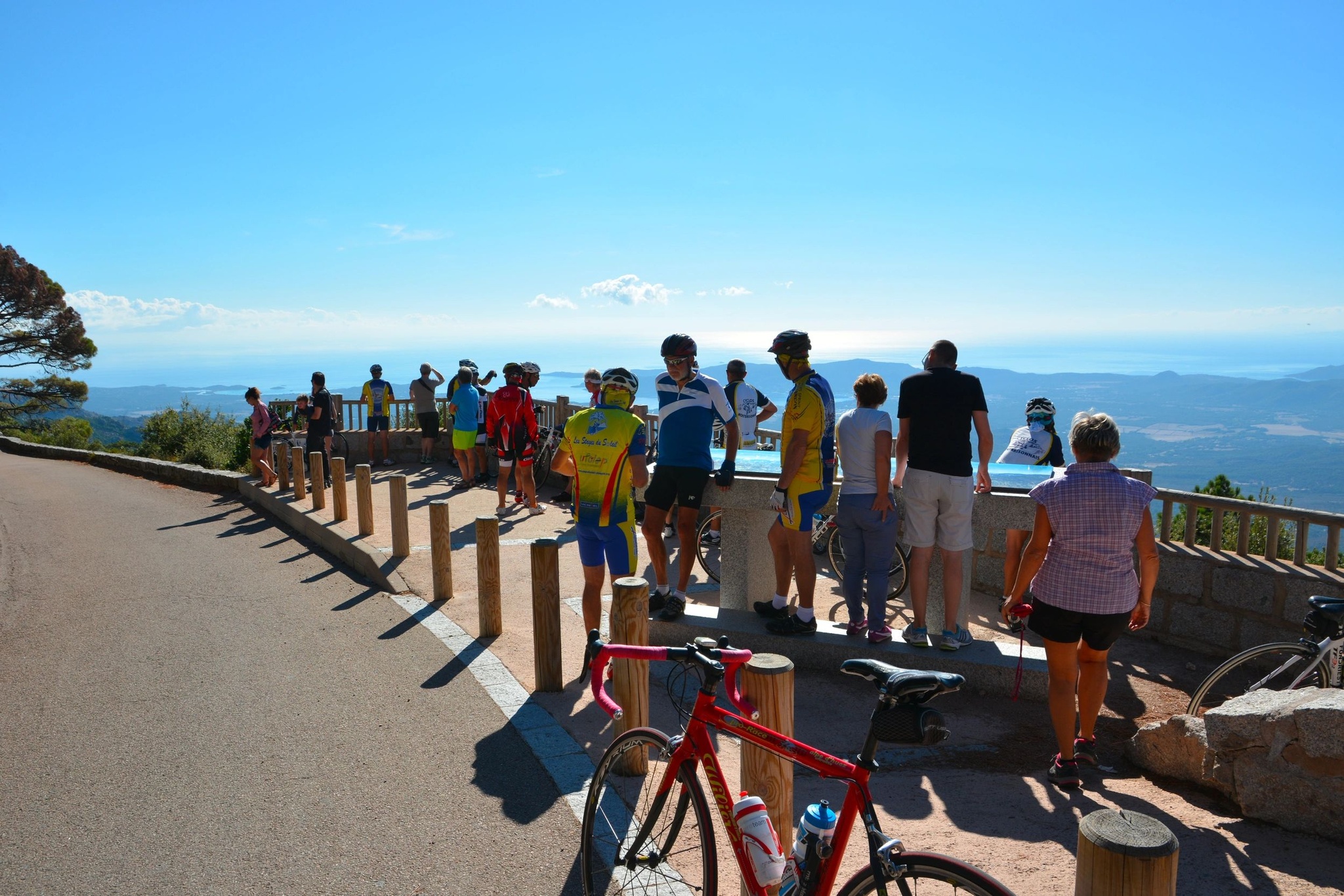 Group of cyclists taking a break overlooking the sea in Corsica.